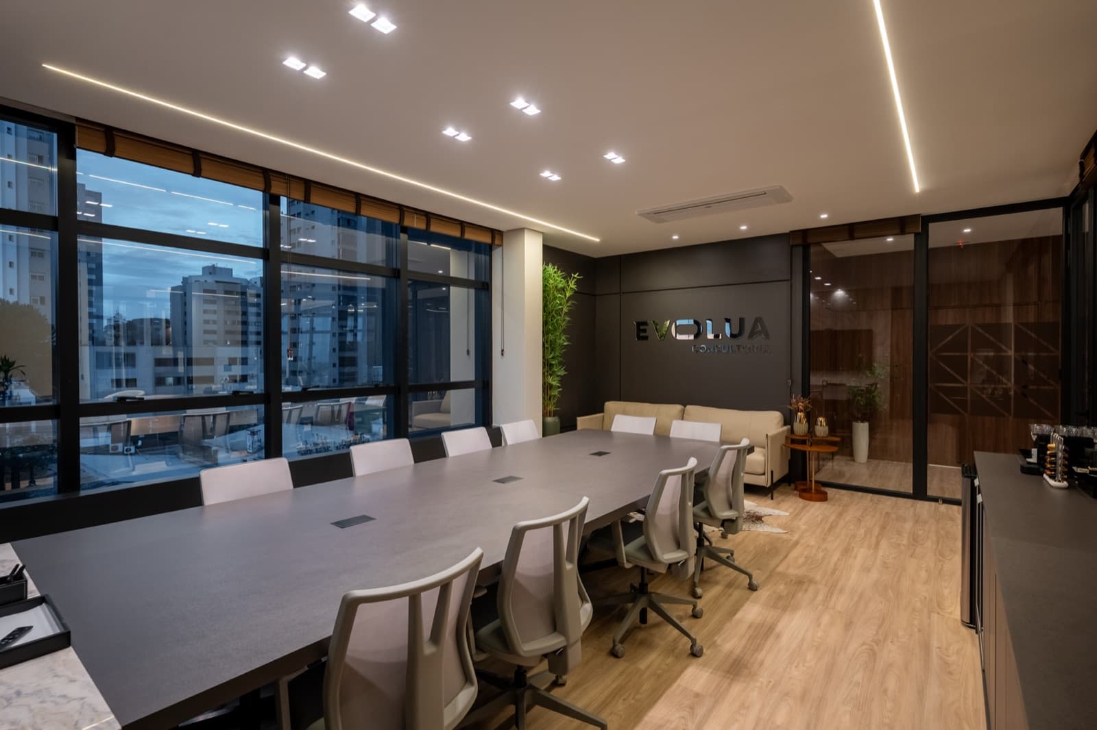 Evolua boardroom with a long table and glass wall bearing the logo