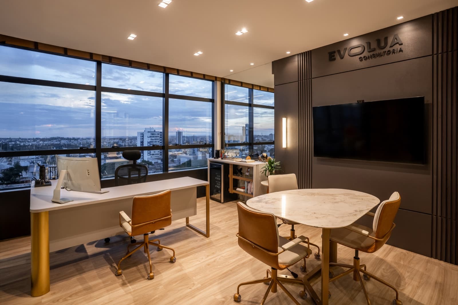 Evolua executive room with dark panel, marble table and dusk city view